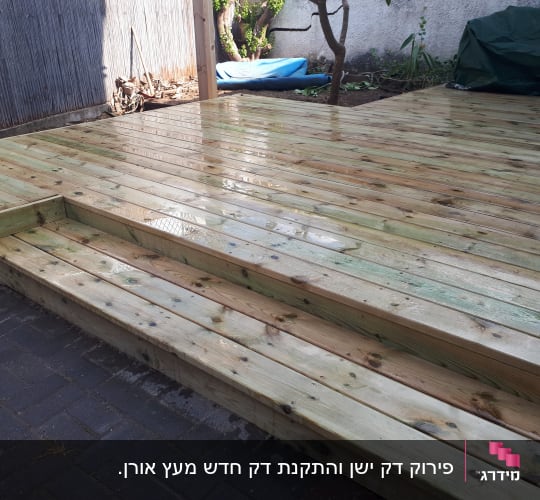 דק עץ חדש בגינה עם מדרגות קטנות